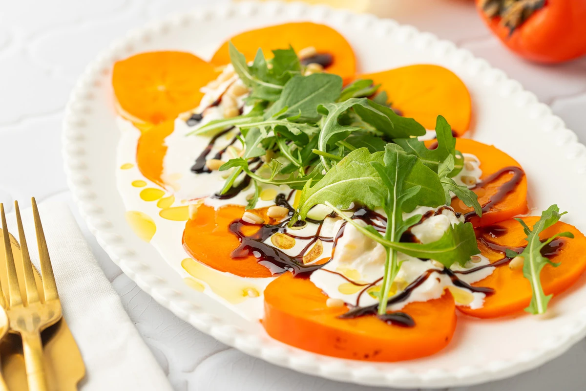 Ich schneide die gelben Früchte in Scheiben und füge nahrhafte Käsesorten hinzu. Dieser Salat ist einfach ein Meisterwerk!